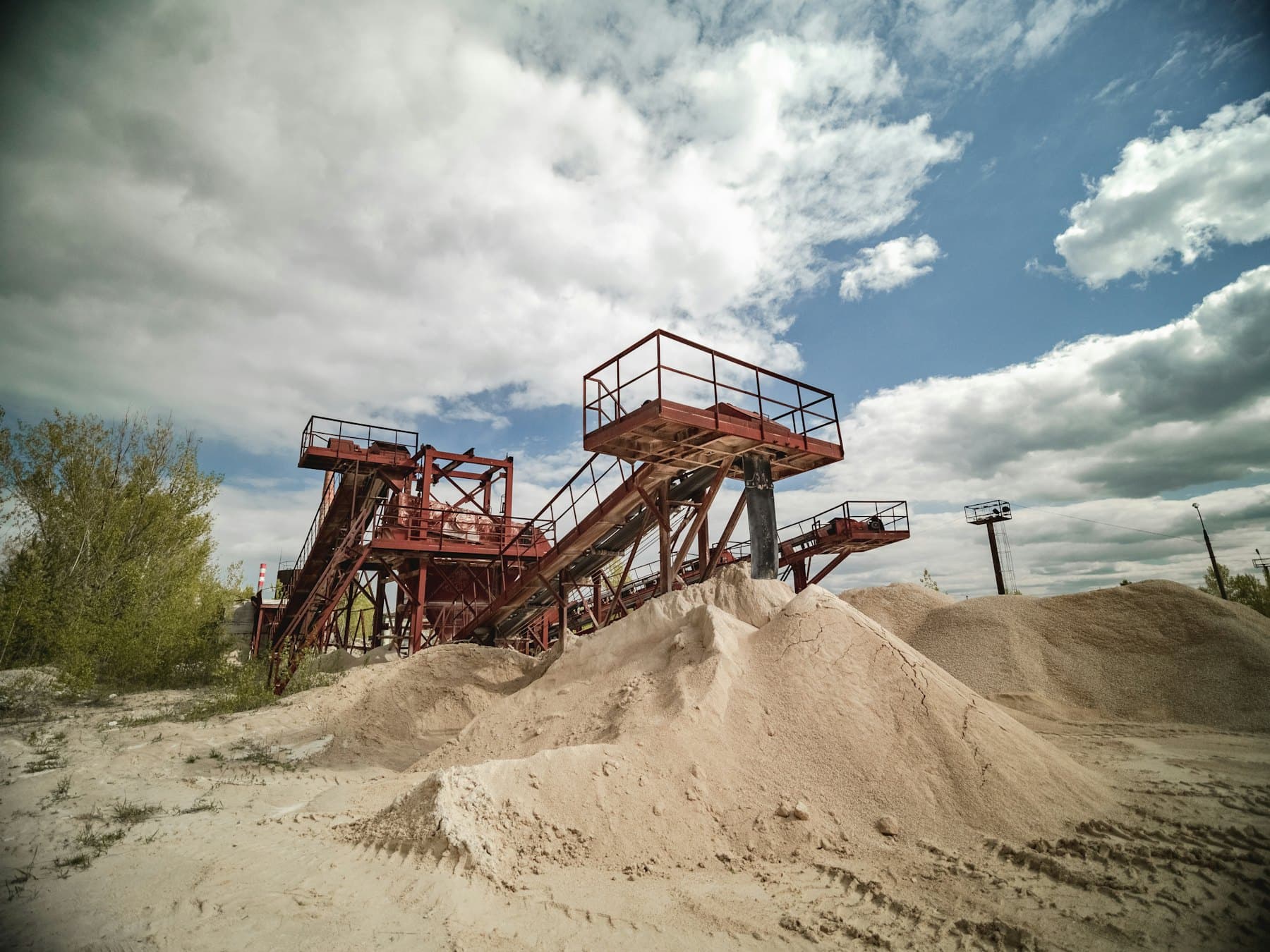 Installation de traitement de granulats avec convoyeurs et tas de sable